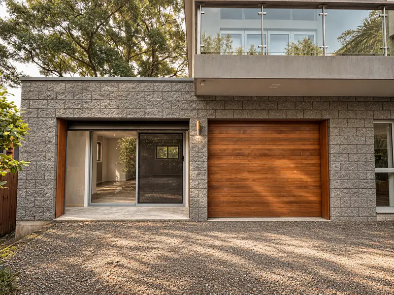 Garage conversion exterior with a glazed entrance beside a timber garage door